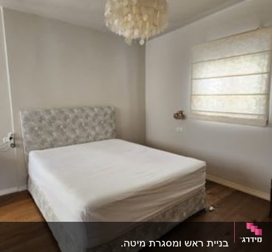 מיטה עם מזרן לבן בחדר שינה